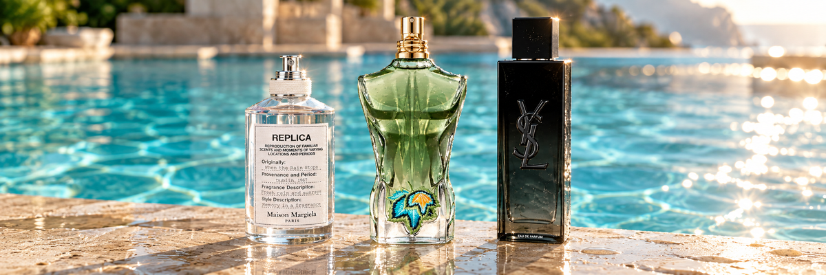 Maison Margiela REPLICA When the Rain Stops, Jean Paul Gaultier Le Beau Paradise Garden and Yves Saint Laurent MYSLF fragrance bottles side by side on wet stone at the edge of a sunlit swimming pool